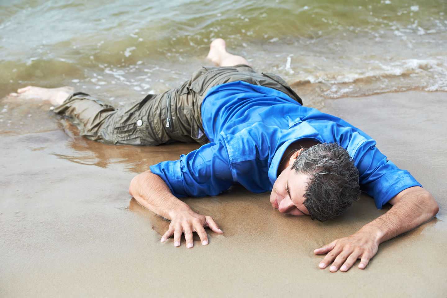 Человек утонул в море. Человек без сознания на берегу. Человек лежит в море.